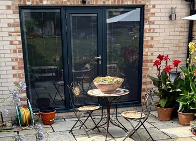 Peaceful patio at Katherapyuk, Crowmarsh Gifford, England with lush plants and elegant seating.