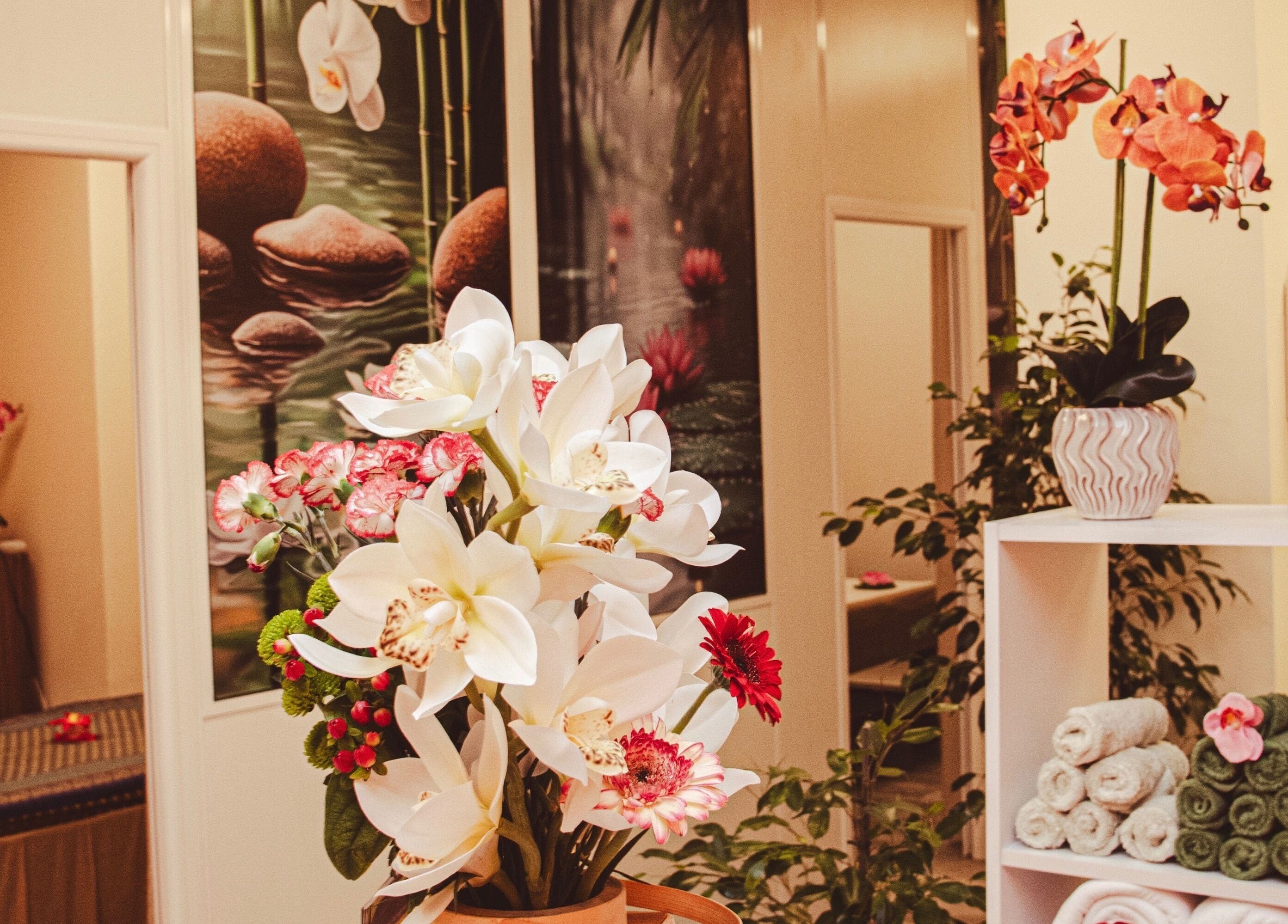 Intérieur apaisant de Ta Thaï Massage à Annemasse, Auvergne-rhône-alpes, FR avec fleurs exotiques.