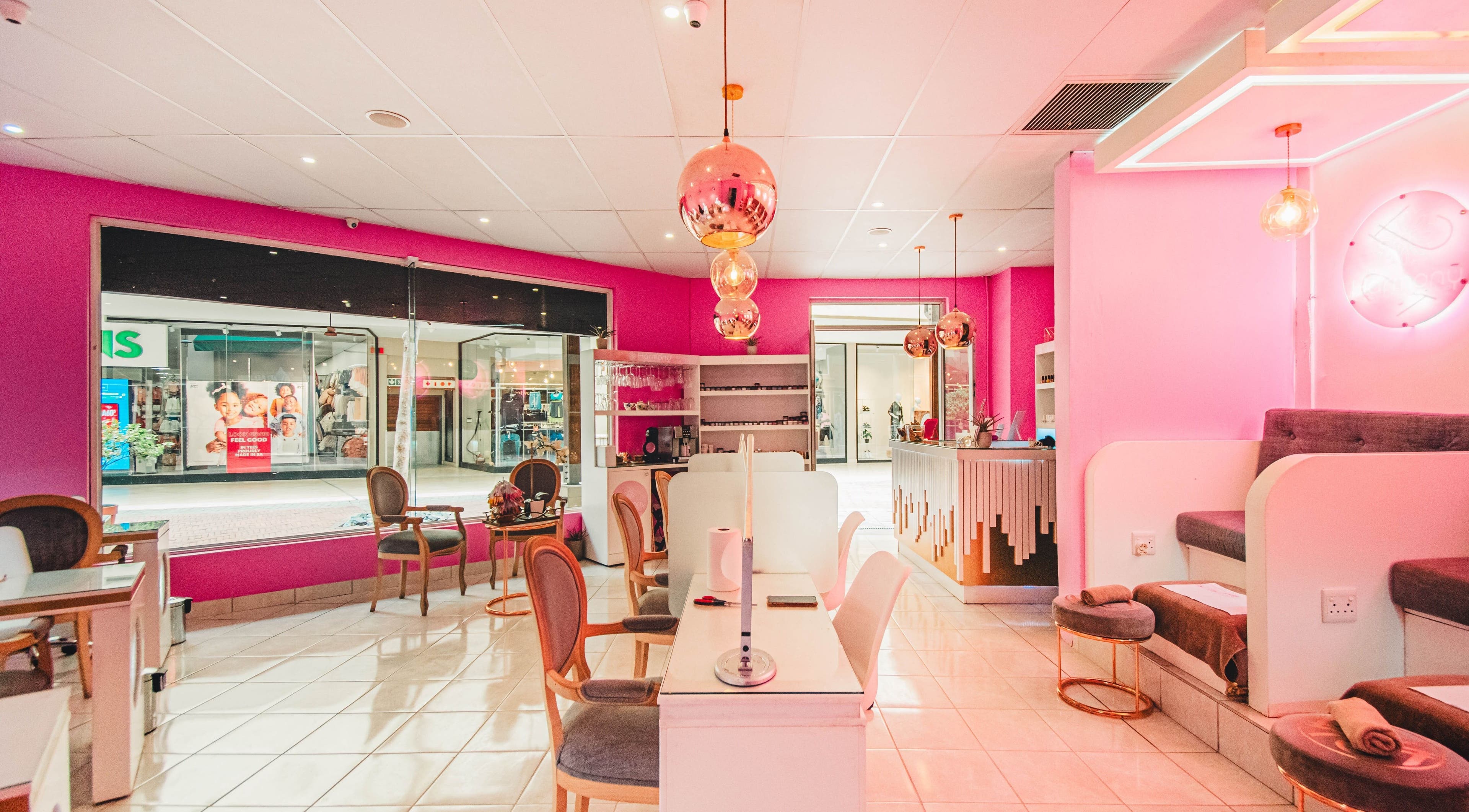 Chic interior of Harmony Nail and Beauty Irene, Centurion, Gauteng, ZA with pink walls and stylish seating.