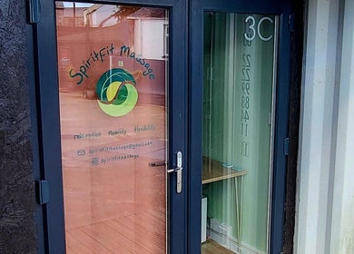 Entrance to Spiritfit Massage, Penryn, England, GB, showcasing welcoming glass door and vibrant logo.