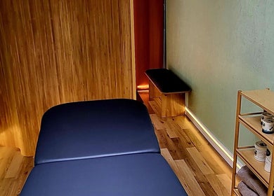 Tranquil massage room at Spiritfit Massage, Penryn, England, GB with wooden accents and soft lighting.