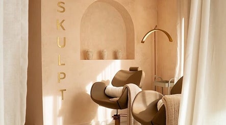 Relaxing treatment room at Mroz Beauty, Salford, England, GB, featuring stylish chairs and warm decor.
