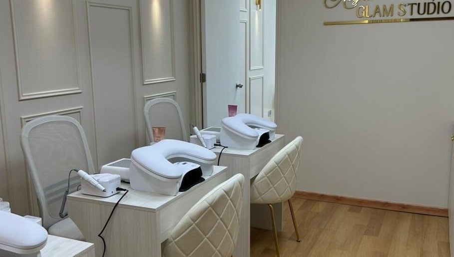 Sala de tratamientos en Alejandra Glam Studio, Las Condes, Región Metropolitana, CL, con sillas y mesas blancas.