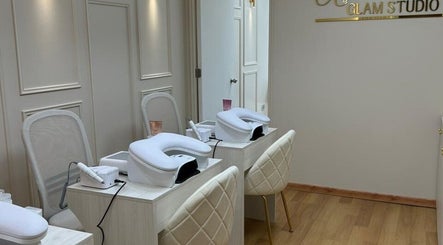 Sala de tratamientos en Alejandra Glam Studio, Las Condes, Región Metropolitana, CL, con sillas y mesas blancas.