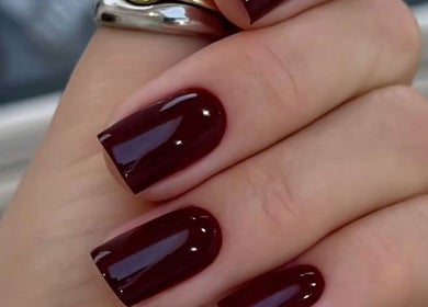 Uñas esmaltadas en rojo oscuro en Alejandra Glam Studio, Las Condes, Región Metropolitana, CL.