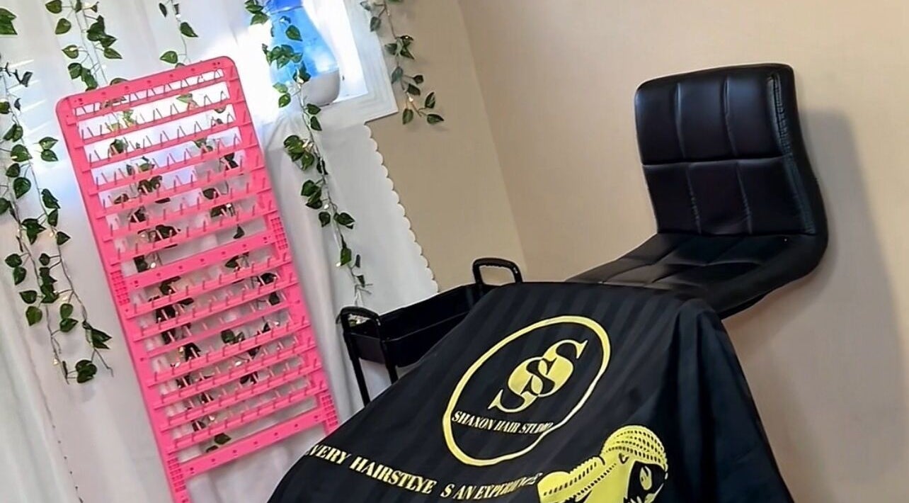 Chic interior of Shaxon Hair Studio in Edmonton, Alberta, CA, featuring a sleek chair and vibrant pink decor.