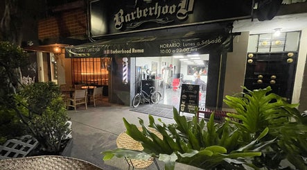 Entrada iluminada de Barberhood Roma en Ciudad De México, MX, mostrando el ambiente acogedor nocturno.