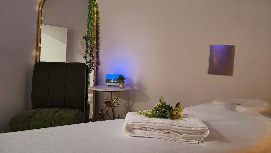 Relaxing massage room at Massage by Laura, Runaway Bay, Queensland, AU with chair, table, and decor.
