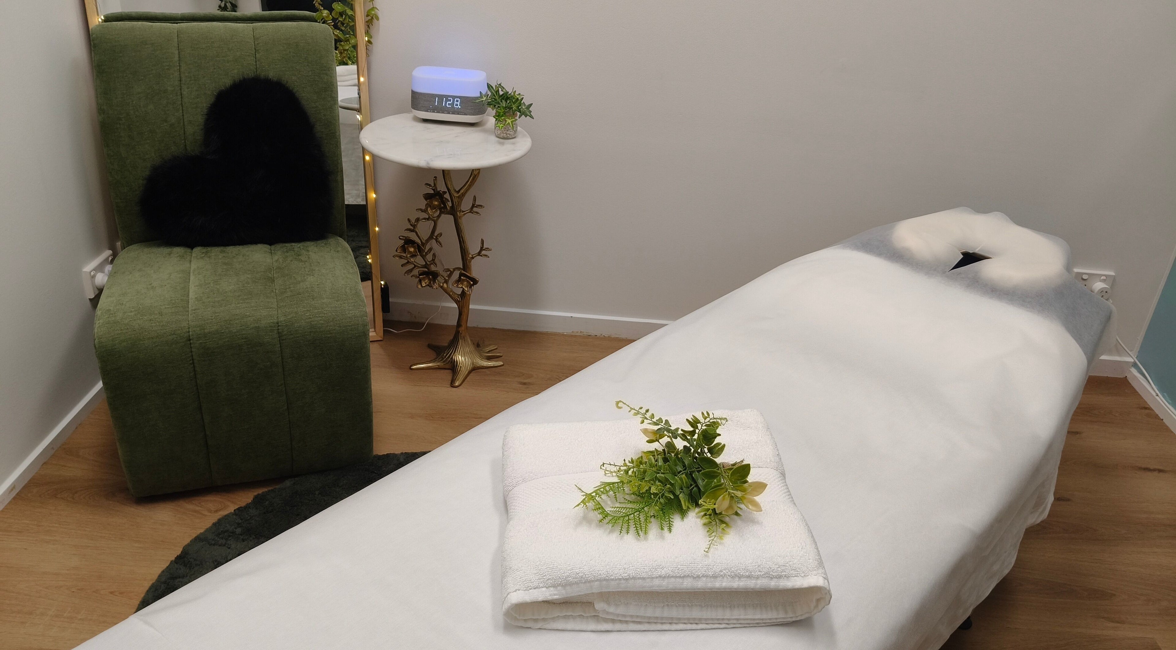 Relaxing massage room at Massage by Laura, Runaway Bay, Queensland, AU, with cozy chair and table.