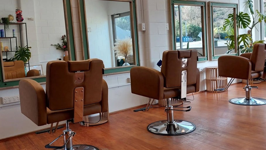 Sleek salon chairs at Botanical Blade hair studio in Dunedin, Otago Region, NZ offer a stylish, modern setting.