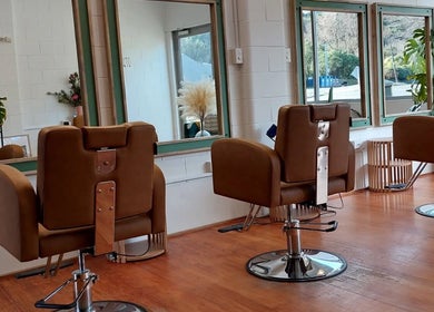 Sleek salon chairs at Botanical Blade hair studio in Dunedin, Otago Region, NZ offer a stylish, modern setting.