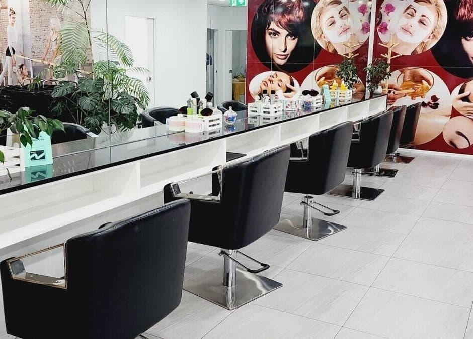 Modern salon interior at Hairmakeover Clendon, Auckland, NZ, featuring stylish chairs and vibrant wall decor.