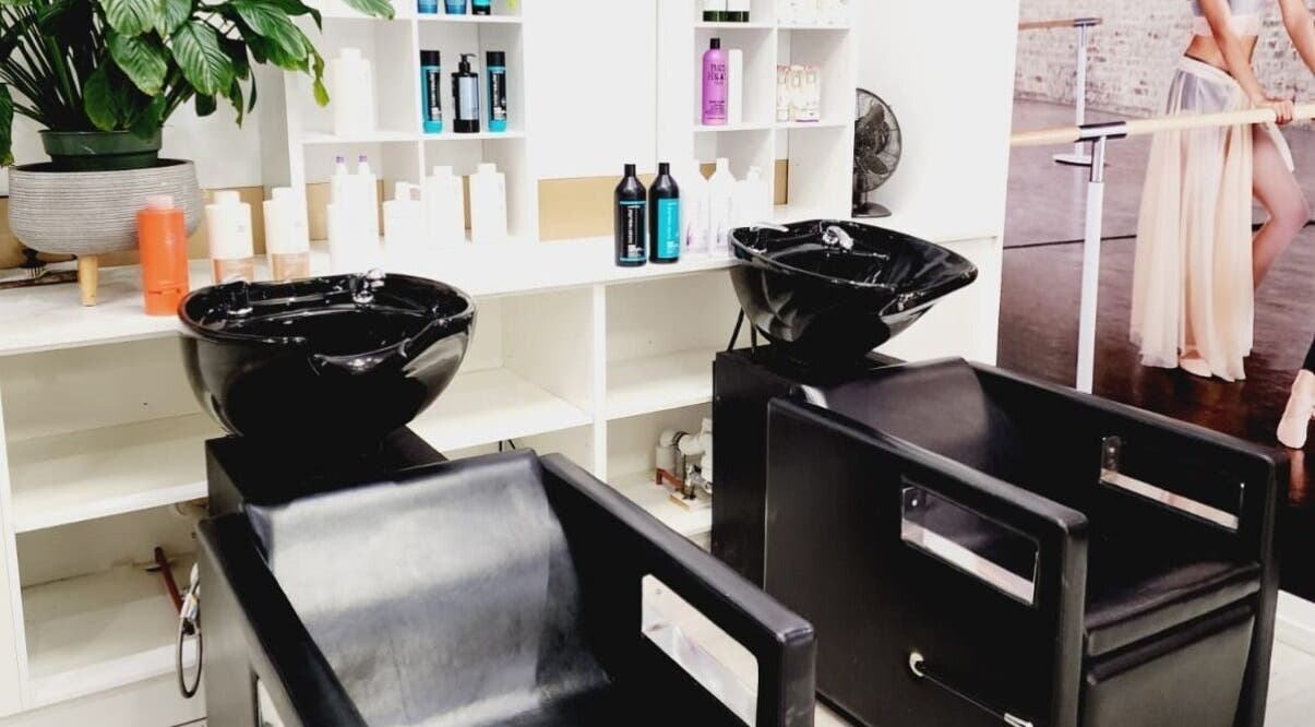 Modern wash stations at Hairmakeover Clendon, Auckland, Auckland, NZ surrounded by a variety of beauty products.