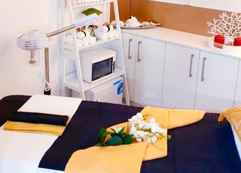 Elegant spa room at Hairmakeover Clendon, Auckland, NZ, featuring a treatment table with cozy towels and decor.