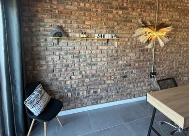 Chic salon corner at Elegant Touch Beauty, Gqeberha, Eastern Cape, ZA with rustic brick wall and elegant decor.