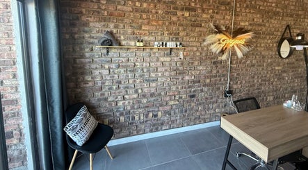 Chic salon corner at Elegant Touch Beauty, Gqeberha, Eastern Cape, ZA with rustic brick wall and elegant decor.