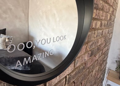 Elegant Touch Beauty in Gqeberha, Eastern Cape, ZA features a cozy room with chic decor and an inspiring mirror message.