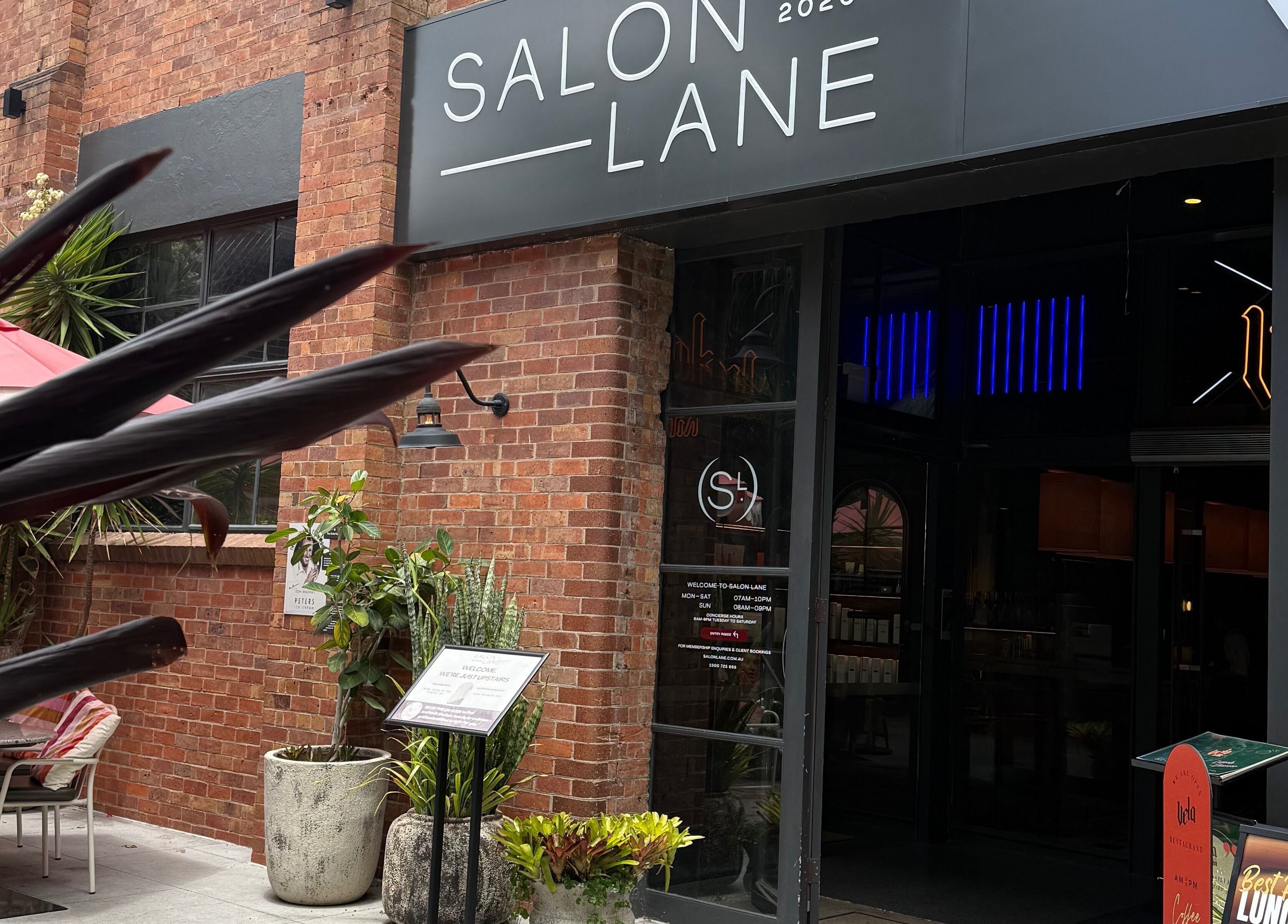 Stylish salon entrance at Narce, West End, Queensland, AU, featuring modern decor and vibrant plants.
