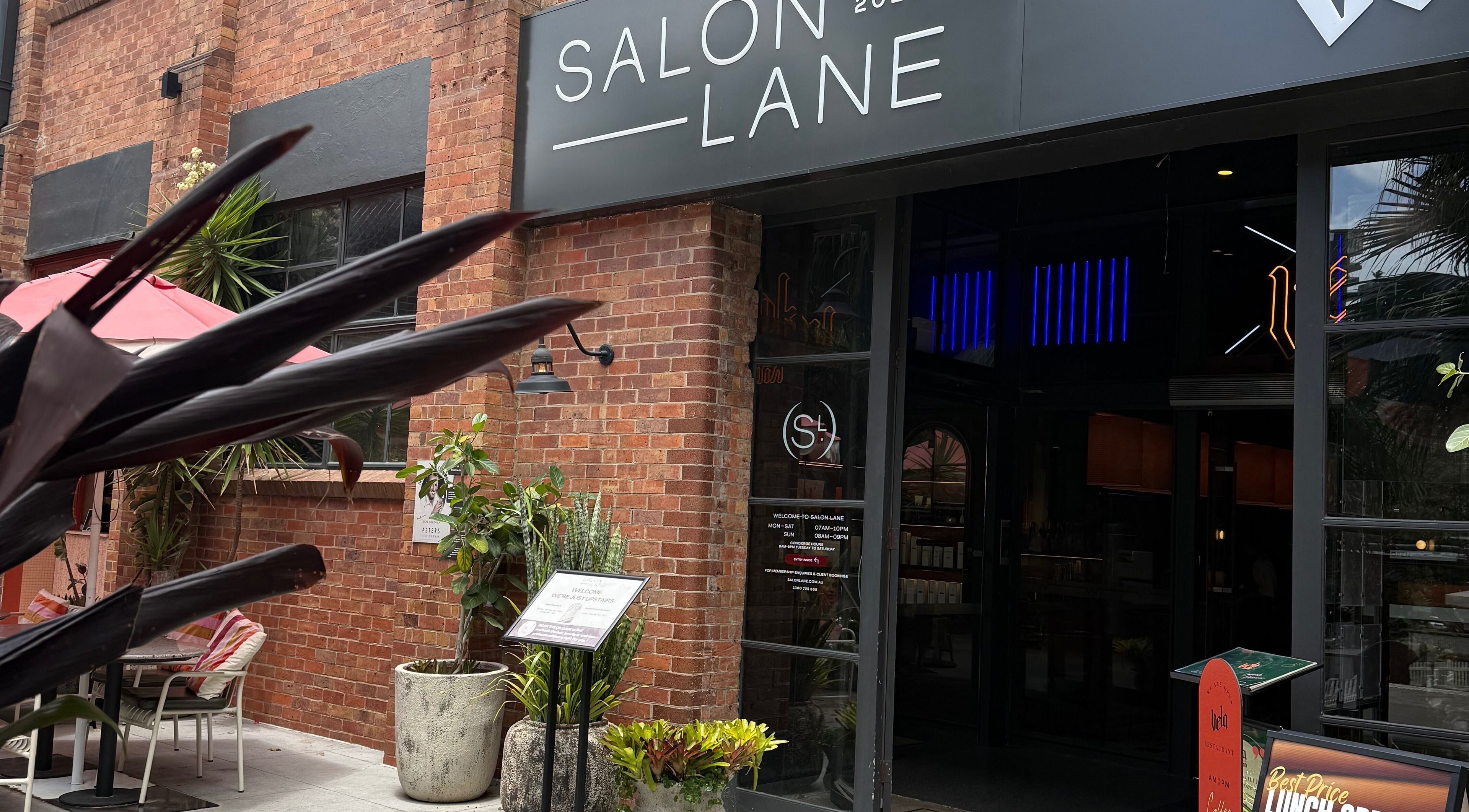 Stylish salon entrance at Narce, West End, Queensland, AU, featuring modern decor and vibrant plants.