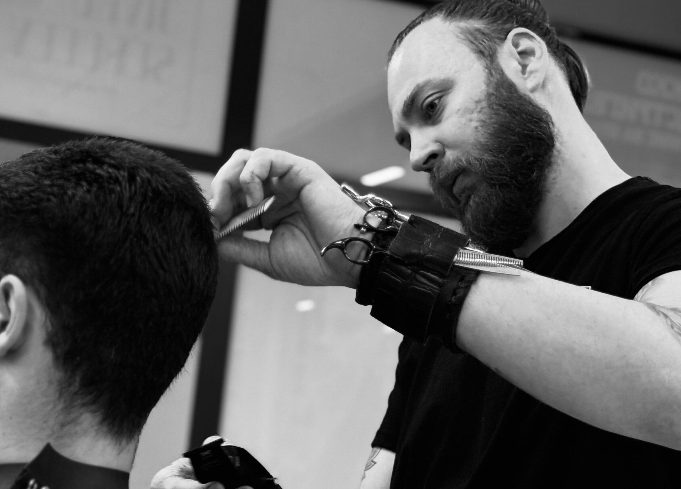 Барбер в Sergeev Barber Club, Варна, Варна, BG, прецизно оформя мъжка прическа.