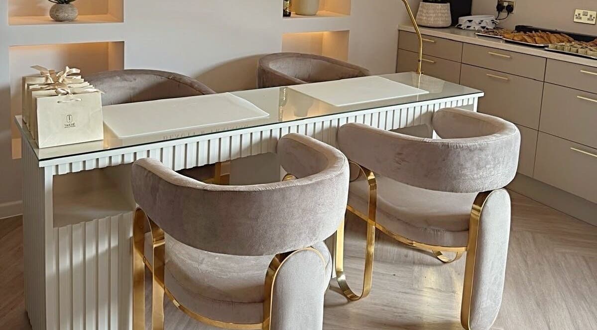 Luxury nail bar setup at Tamoré Beauty, Birmingham, England, GB featuring plush chairs and a sleek counter.