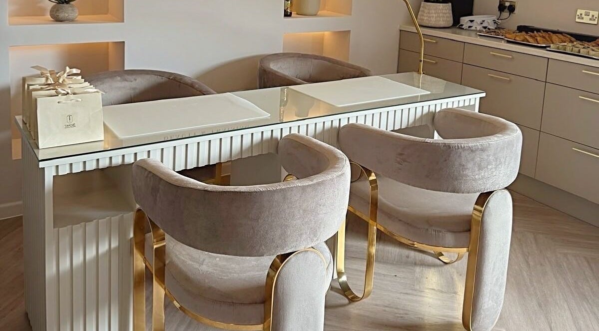 Luxury nail bar setup at Tamoré Beauty, Birmingham, England, GB featuring plush chairs and a sleek counter.