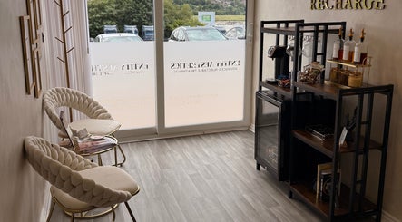 Elegant seating area at Entity Aesthetics, Rochester, England, GB with plush chairs and refreshment bar.