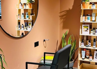 Elegant beauty corner at Hoipolloi Studio in Winchester, England, GB featuring shelves with products and a mirror.