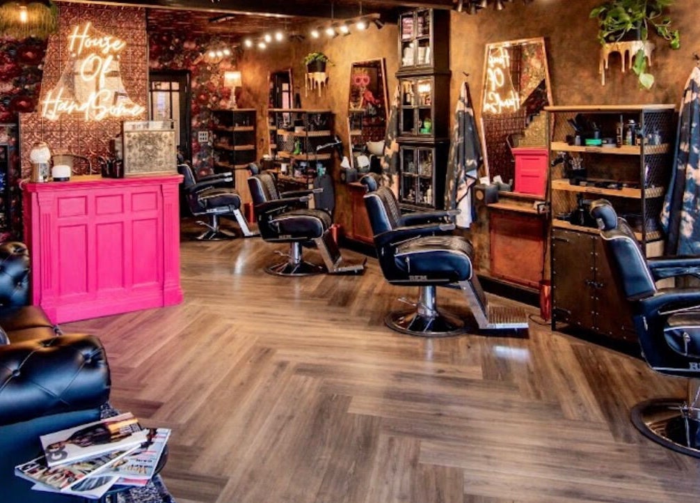 Stylish interior of J wavey in Kempston, England, GB with chic barber chairs and vibrant decor.
