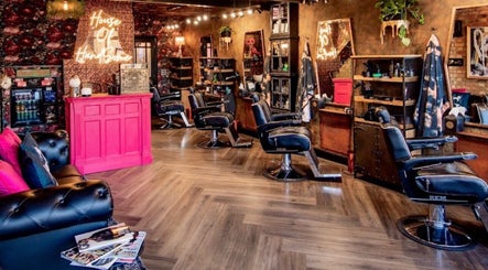 Stylish interior of J wavey in Kempston, England, GB with chic barber chairs and vibrant decor.