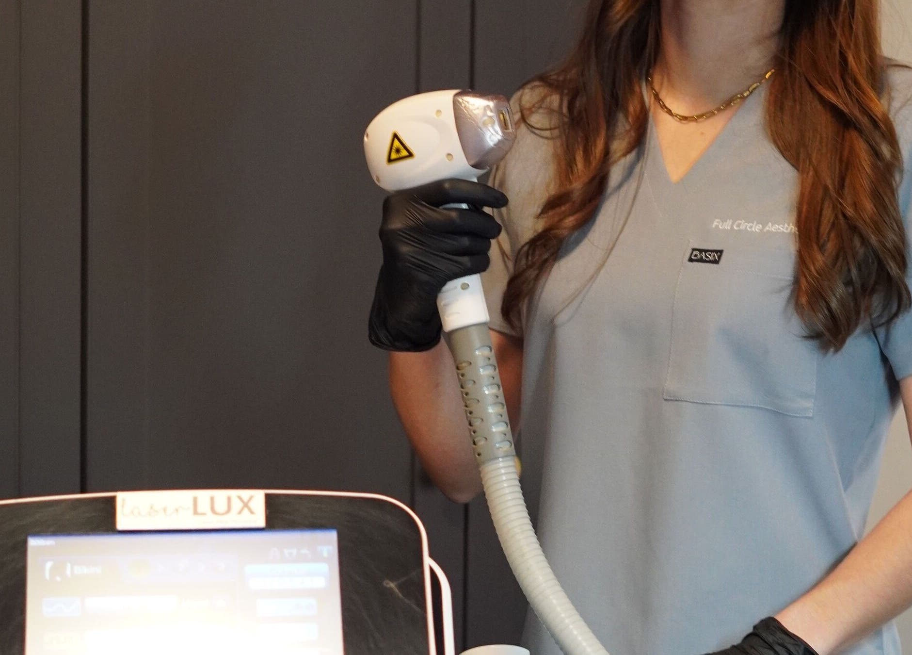 Expert with laser device at Full Circle Aesthetics, Pretoria, Gauteng, ZA, ready for treatment.