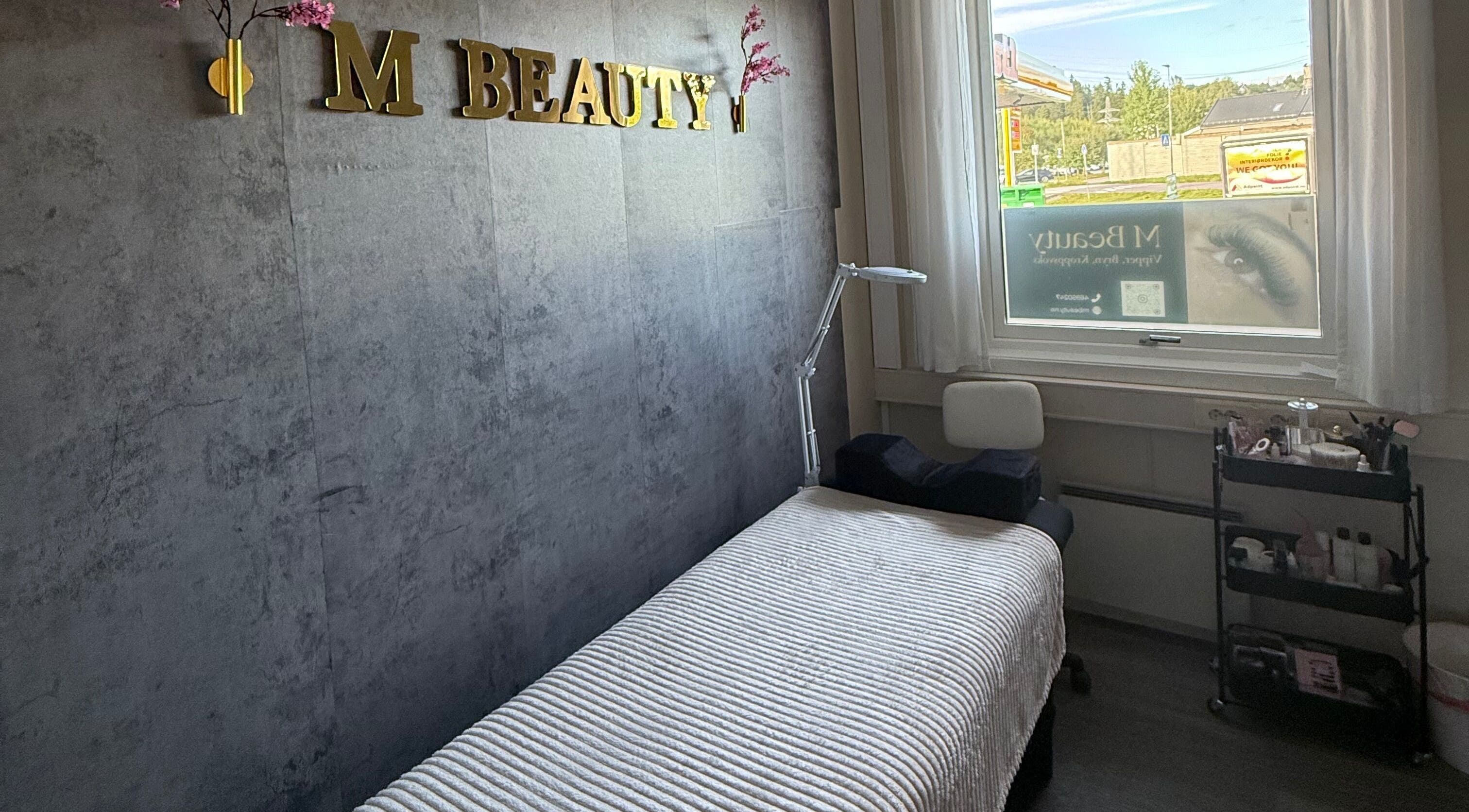 Koselig behandlingsrom ved M Beauty i Skedsmokorset, Akershus, NO, med komfortabel benk og naturlig lys.
