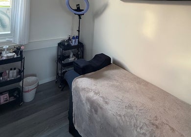 Behandlingsrom ved M Beauty, Skedsmokorset, Akershus, NO med myk benk og pleieprodukter.
