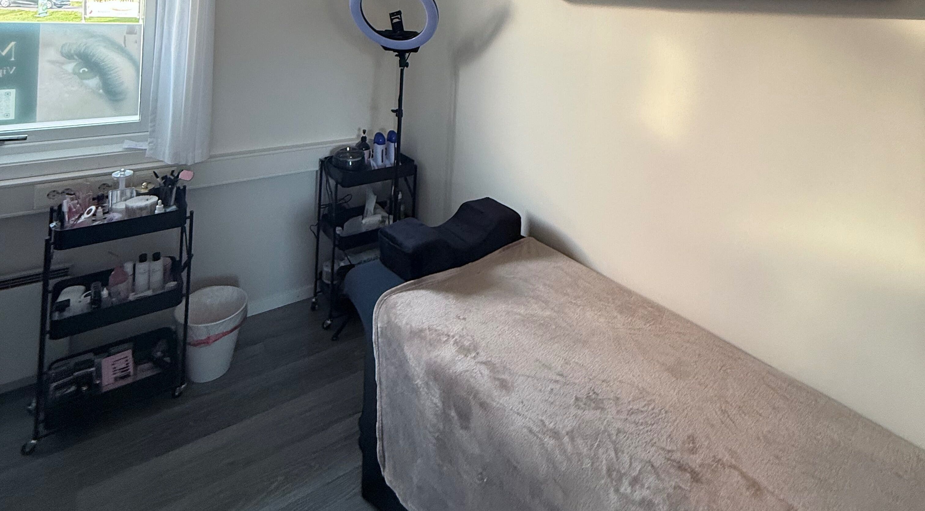 Behandlingsrom ved M Beauty, Skedsmokorset, Akershus, NO med myk benk og pleieprodukter.