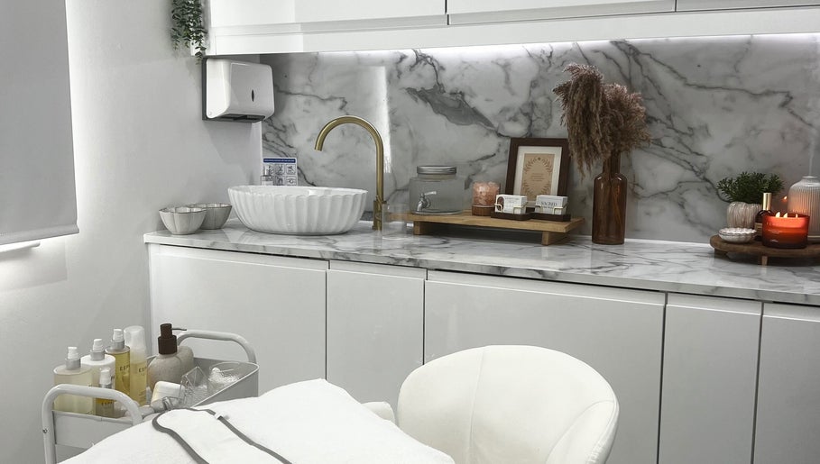Elegant treatment area at Sacred Skin and Wellness, Kingsteignton, England, GB with marble counter and cozy decor.