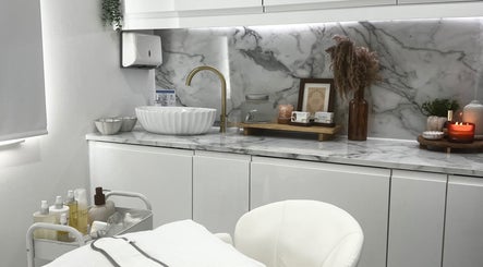 Elegant treatment area at Sacred Skin and Wellness, Kingsteignton, England, GB with marble counter and cozy decor.