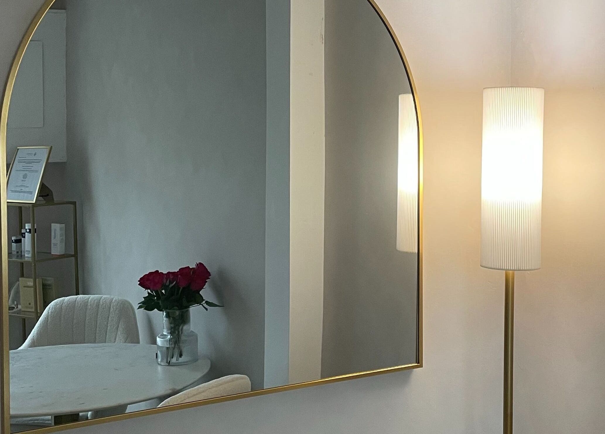 Elegant decor at The Skin Studio Cirencester, featuring a mirror, roses, and soft lighting in Cirencester, England, GB.