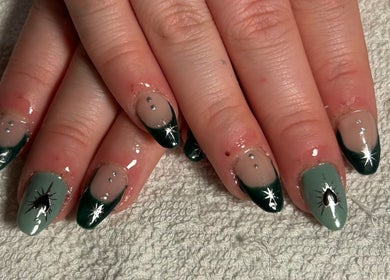 Chic emerald nail art with star accents at Aura Nails, Great Oxendon, England, GB. Perfect for stylish elegance.