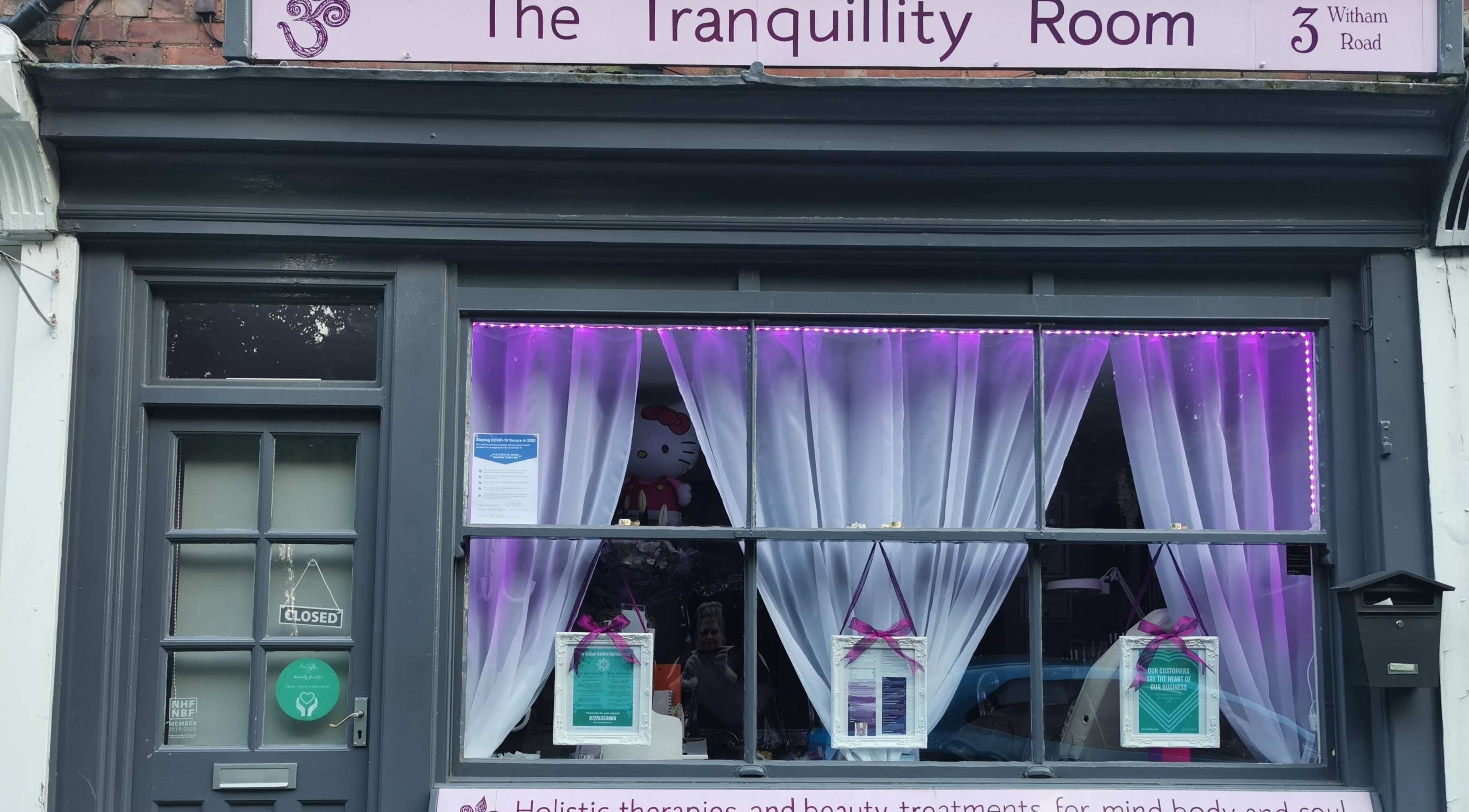 Exterior of The Tranquillity Room in Woodhall Spa, England, with purple-lit curtains and closed sign.