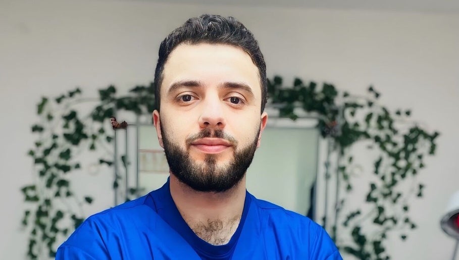 شخص يبتسم في عطار لندن london Apothecary، لندن، إنجلترا، GB، محاط بالخضاريات.