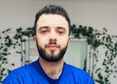 شخص يبتسم في عطار لندن london Apothecary، لندن، إنجلترا، GB، محاط بالخضاريات.