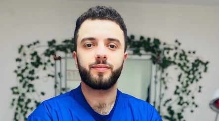 شخص يبتسم في عطار لندن london Apothecary، لندن، إنجلترا، GB، محاط بالخضاريات.