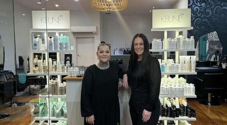 Two stylists at Elegance & Edge Hair in Dunedin, Otago Region, NZ, showcasing premium hair products.