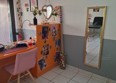 Coin beauté coloré à Ink & Glow, Narbonne, Occitanie, FR, avec table orange et miroir doré.