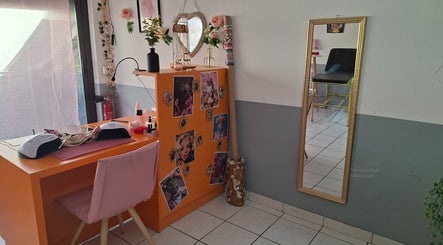Coin beauté coloré à Ink & Glow, Narbonne, Occitanie, FR, avec table orange et miroir doré.