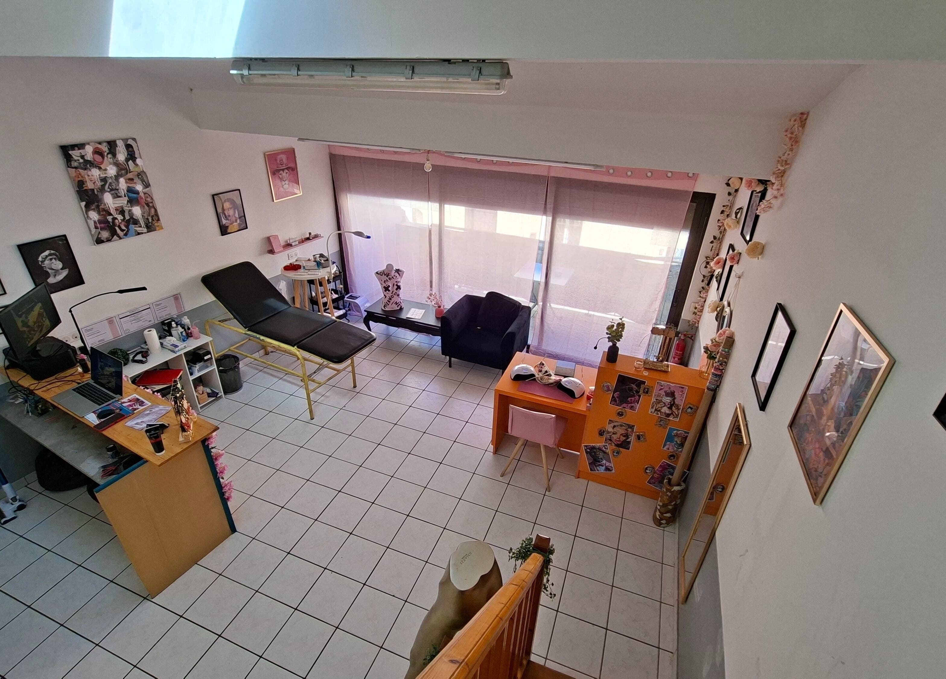 Intérieur d'Ink & Glow à Narbonne, Occitanie, FR avec fauteuil et décor artistique.