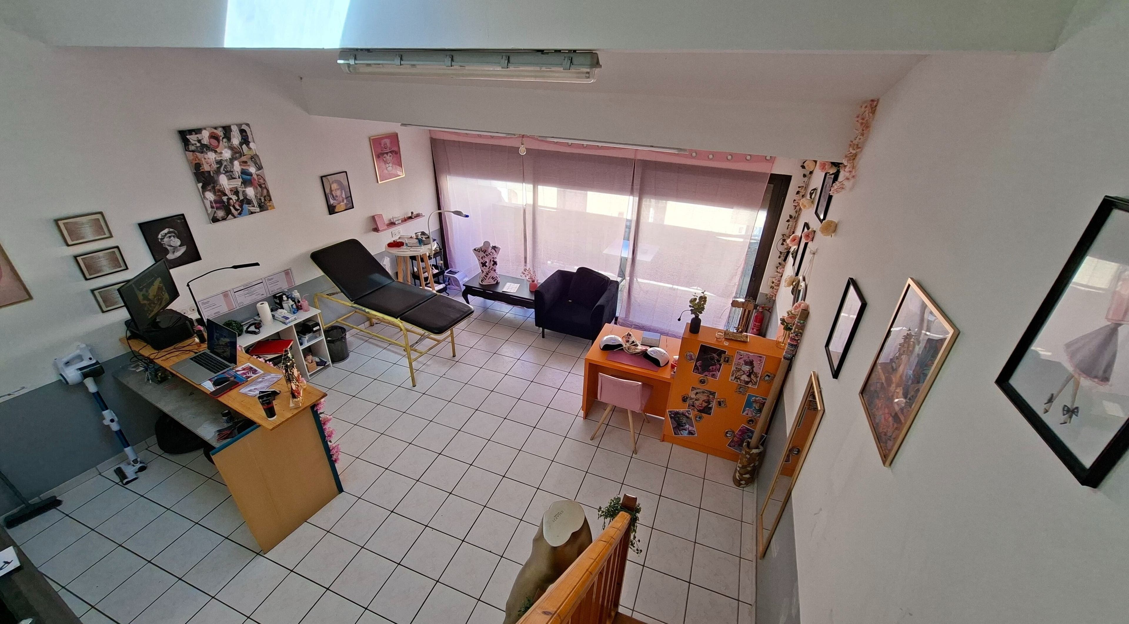 Intérieur d'Ink & Glow à Narbonne, Occitanie, FR avec fauteuil et décor artistique.