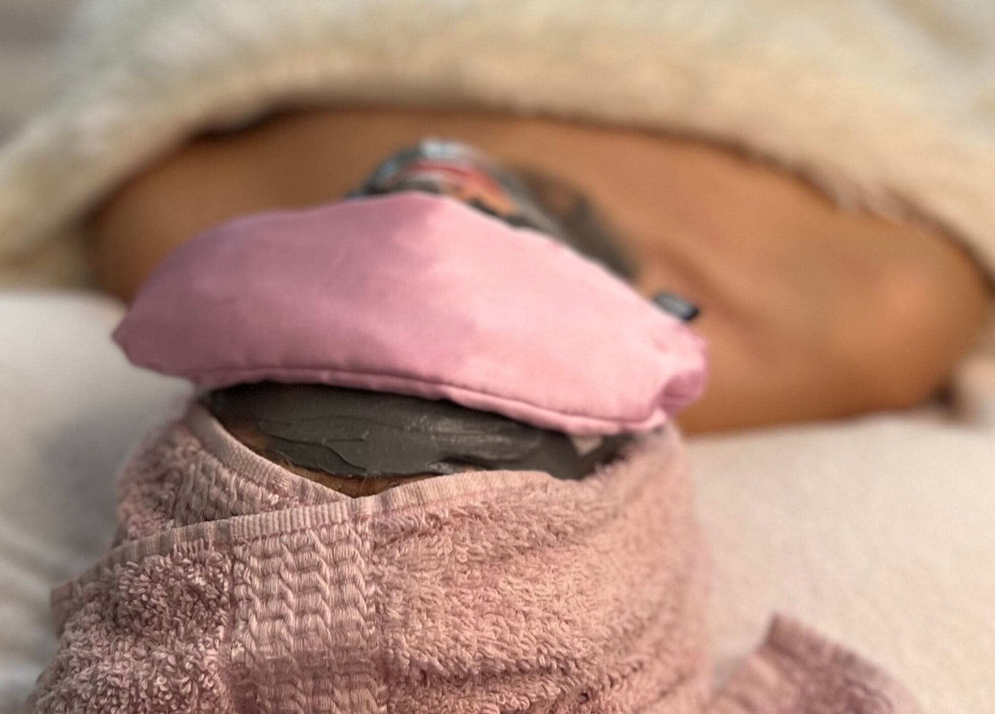 Relaxing body wrap at FIZIO & BEAUTY HOUSE, Mārupe, Mārupes Novads, LV with pink towel and mask.