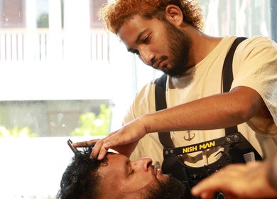 Coiffure professionnelle chez Mister Hype Saint-Paul à Saint-paul, Saint-paul, RE. Un barbier coupe les cheveux d'un client.
