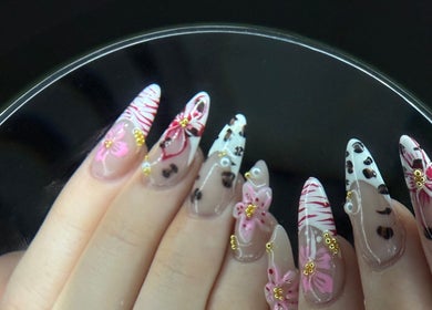 Intricate floral nail art at Nailsbyaimz, Kempston, England, GB, showcasing delicate pink and gold designs.